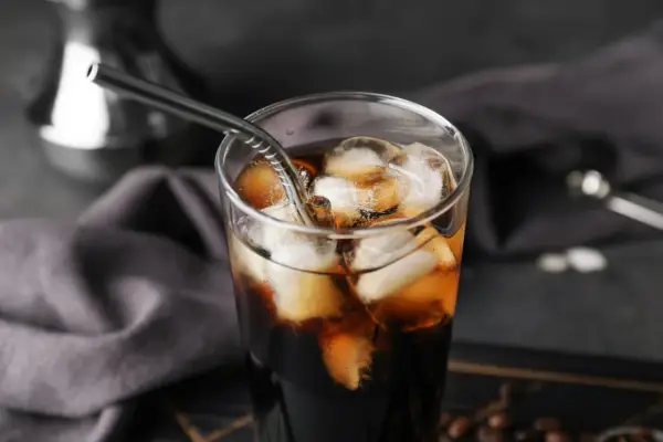 Erfrischender Cold Brew Kaffee in einem Glas mit Eiswürfeln und einem Metallstrohhalm. Perfekt für heiße Tage.